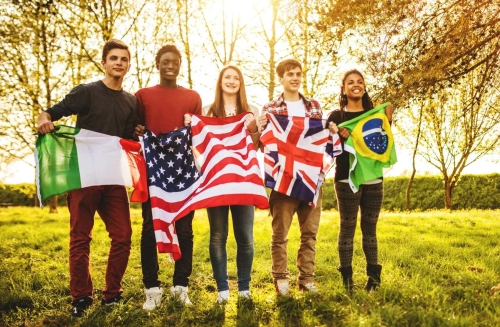 5 people standing next to each other with flags of Italy, USA, United Kingdom and Brasil