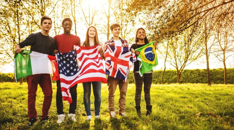 5 people standing next to each other with flags of Italy, USA, United Kingdom and Brasil