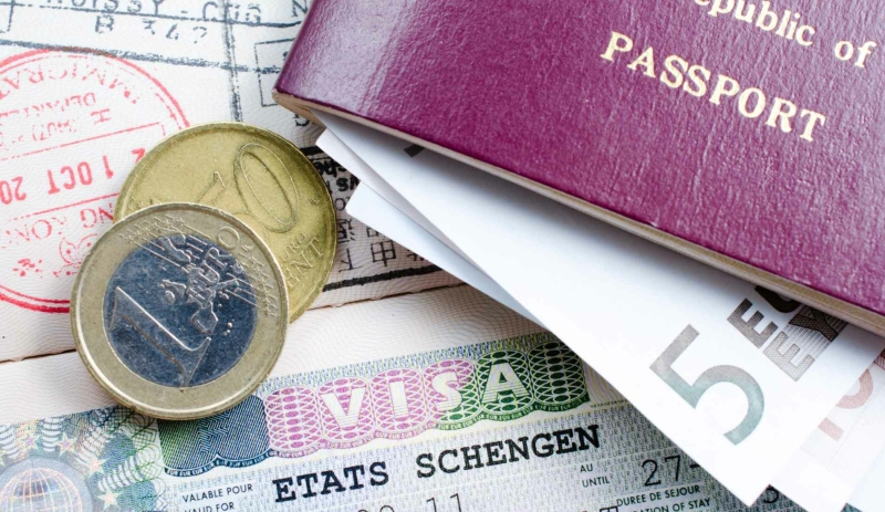 Schengen Visa with passport and euro coins