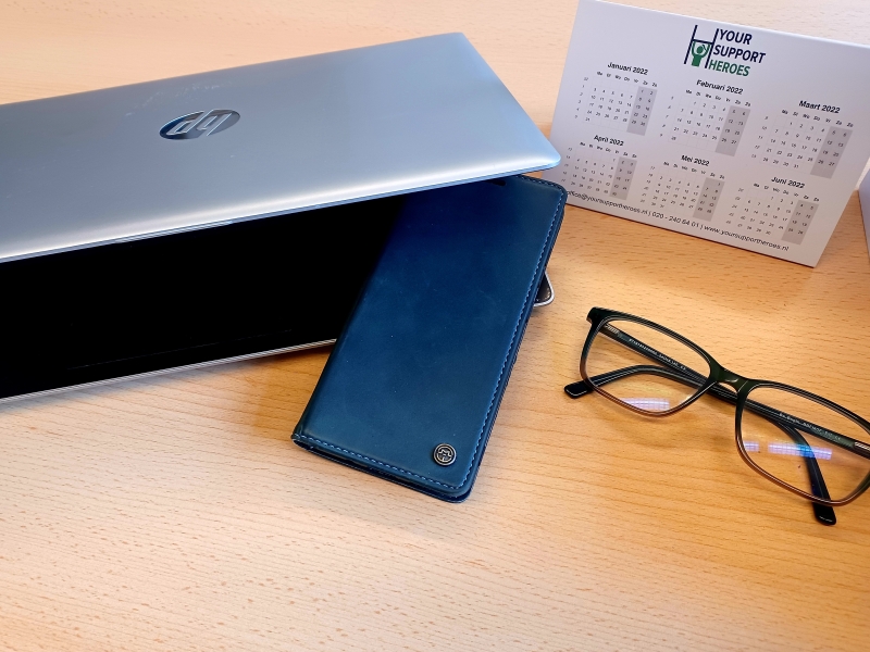 Afbeelding met een laptop en smartphone en een bril en kalender