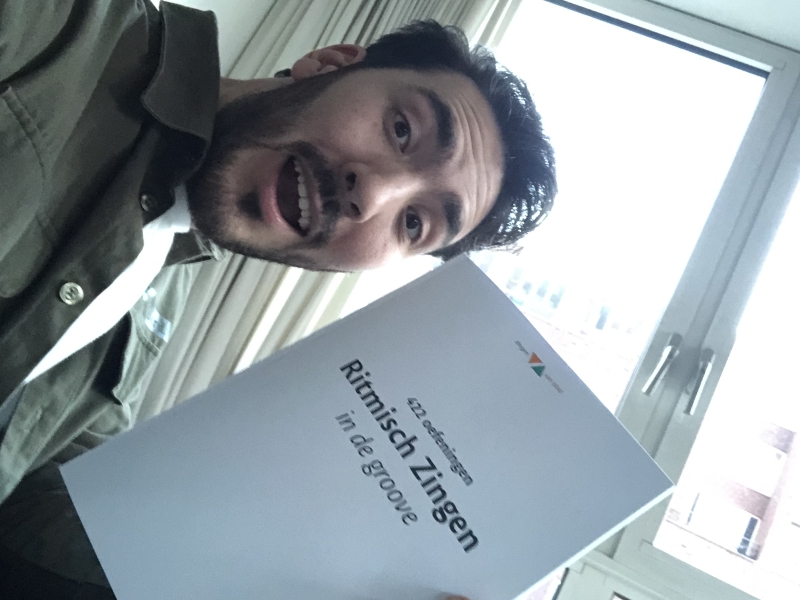 Niek houdt zijn werkboek Ritmisch Zingen In De Groove vast