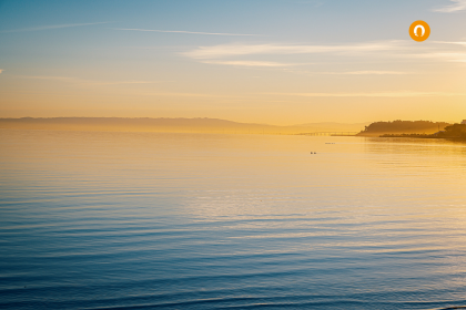 Afbeelding van ondergaande zon boven een meer