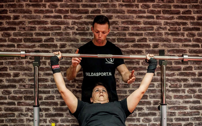 Delda Sport personal training Amsterdam Foto van vrouw aan het gewichtheffen met personal trainer