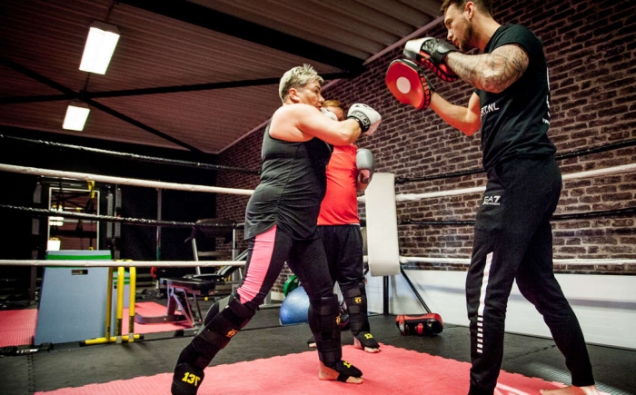 Foto van mensen aan het kickboksen met personal trainer