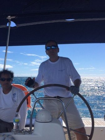 Gasten aan het roer tijdens de Golden Rock Regatta zelf sturen tijdens een regatta