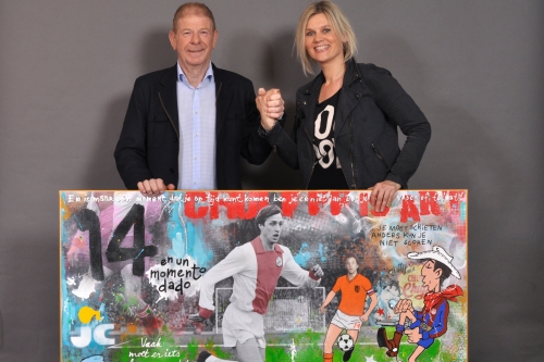 Frits Barend, ambassadeur van de Cruyff Foundation, neemt het eerste Cruijff schilderij in ontvangst van kunstenaar Nikki Genee.